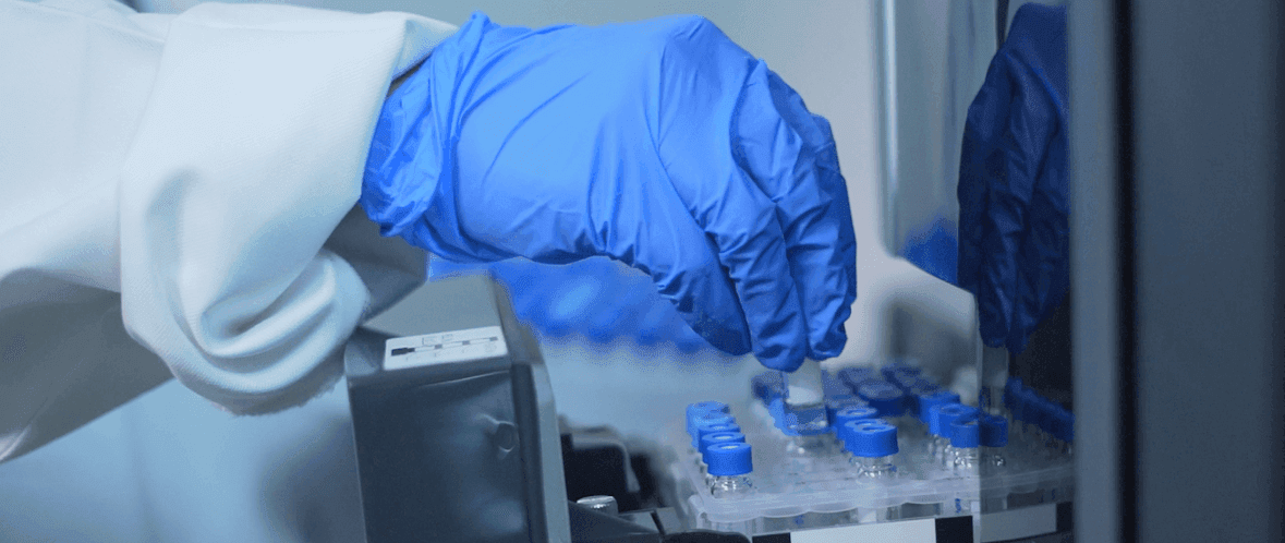 Laboratory technician handling blood sample tubes for clinical pathology testing